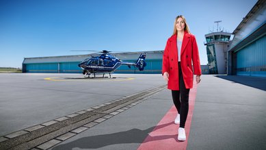 Man sieht Paula von der Bundespolizei auf einem Hubschrauberlandeplatz vor einem Hubschrauber laufen.