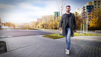 Man sieht Fatih von der Bundesagentur für Arbeit in einem städtischen Viertel laufen.
