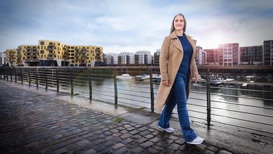 Man sieht Ina vom Bundeskriminalamt vor einem Fluss an einem Geländer laufen.