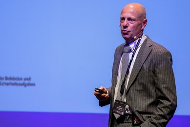 Man sieht Tom Pasternak von der BDBOS auf einer Veranstaltung, wie er zu einem Publikum spricht. Mit ihm wurde ein Interview geführt. Copyright Bild: Konstantin Gastmann
